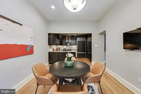 a kitchen with a dining table chairs and a microwave