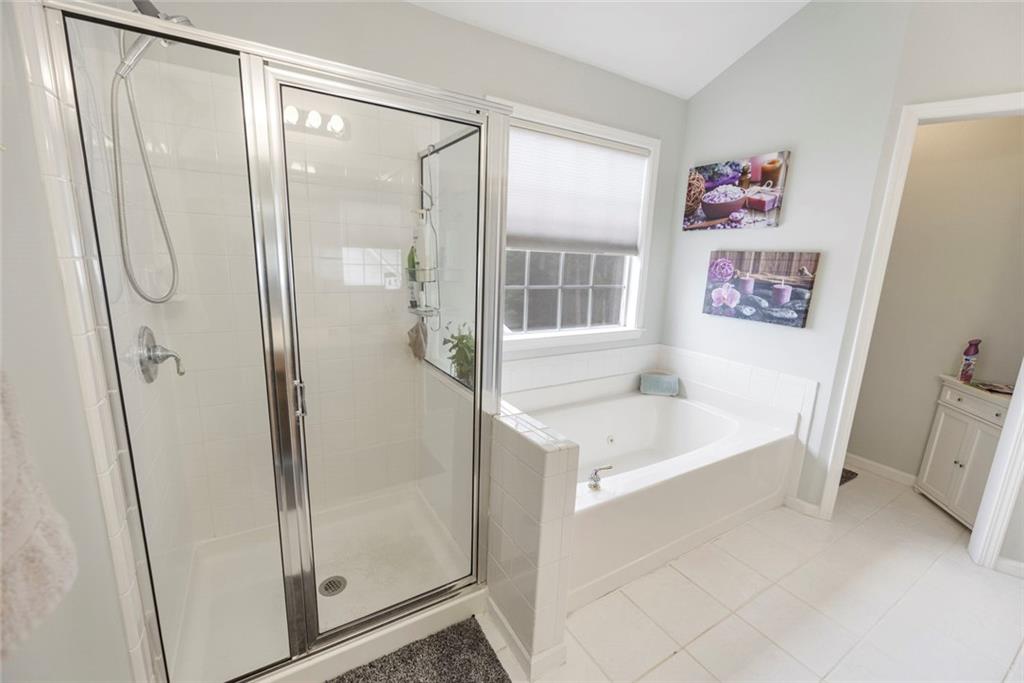 3905 Embassy Way Lilburn, GA 30047 - Photo 13 of 29 a bathroom with a tub a sink and a large mirror