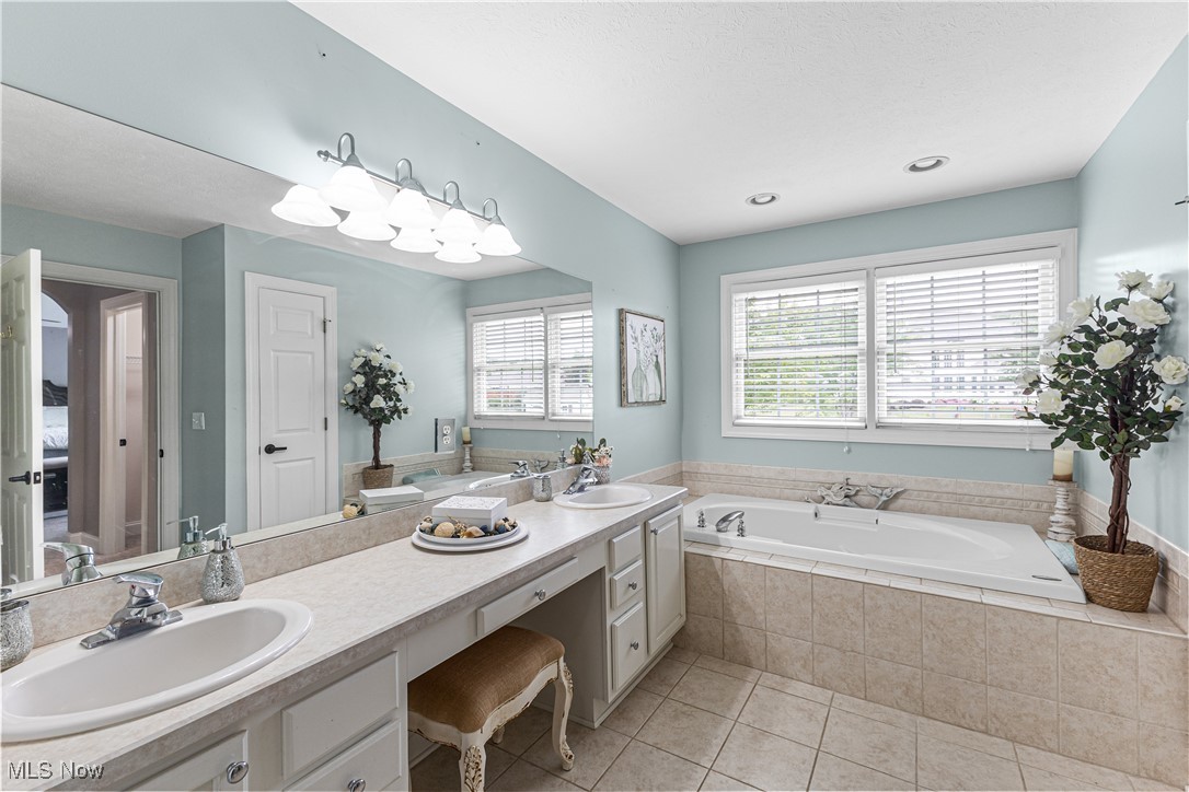 2251 Timber Ridge Trail Streetsboro, OH 44241 - Photo 32 of 48 Master bathroom featuring dual vanity, tiled tub, and tile patterned flooring