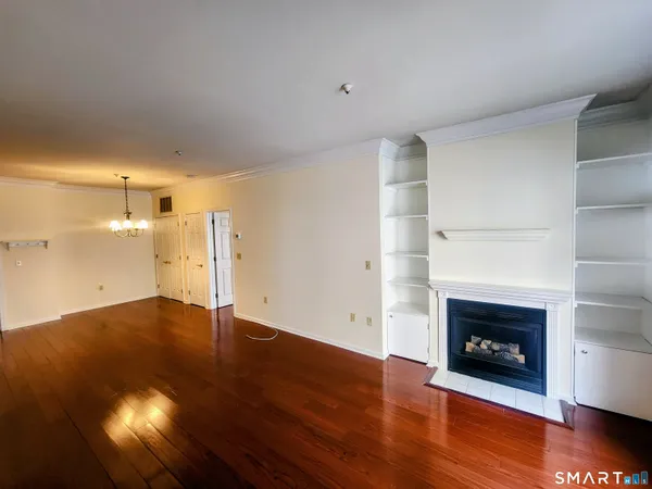 a view of empty room with wooden floor and fireplace