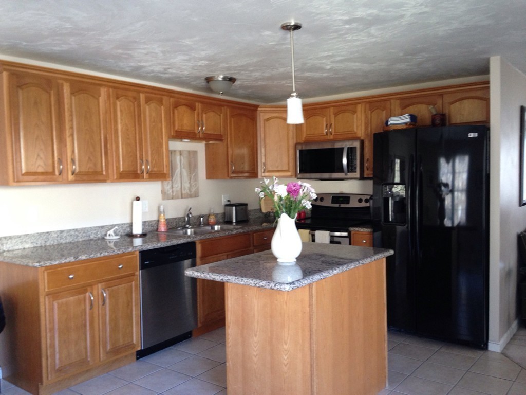 52 Honeysuckle Road Worcester, MA 01607 - Photo 2 of 15 a kitchen with granite countertop a sink refrigerator and microwave