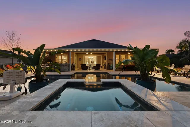 a room with a table chairs wooden floor and a large window