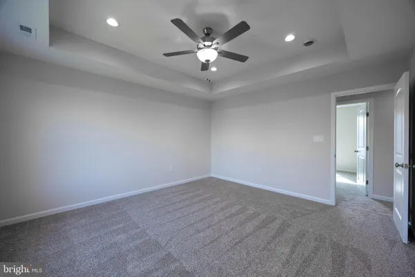 wooden floor in an empty room and a ceiling fan