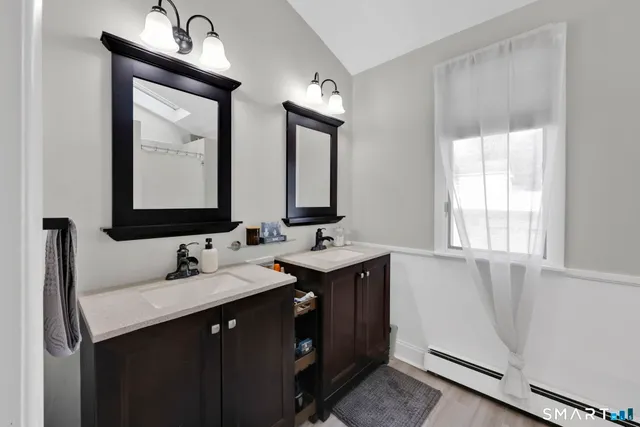 a bathroom with 2 sink and a mirror