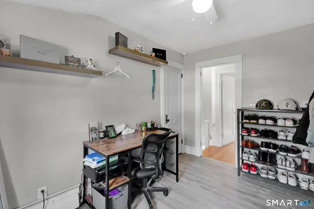 a view of a workspace with furniture and wooden floor