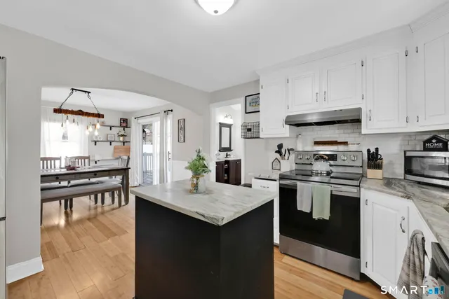 a kitchen with granite countertop white cabinets and appliances