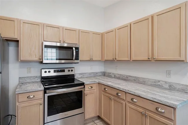 a kitchen with granite countertop white cabinets and stainless steel appliances