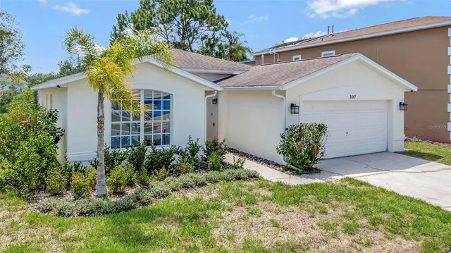 a front view of house with a garden