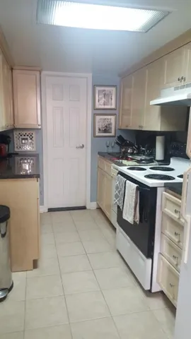 a kitchen with granite countertop a stove top oven and cabinets