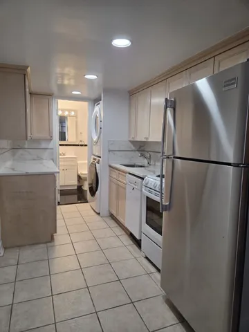 a kitchen with a refrigerator a stove top oven and cabinets