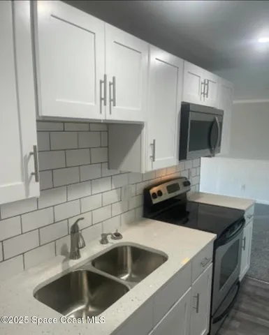 a kitchen with a sink and a stove top oven