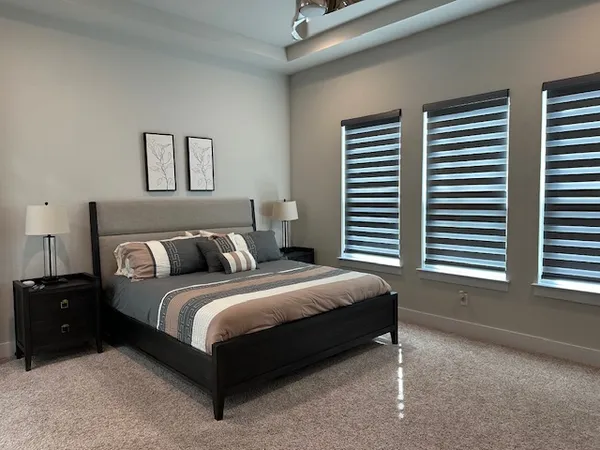 a spacious bedroom with a bed and a window