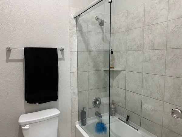 a bathroom with a shower a toilet and sink