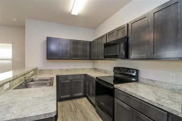 a kitchen with stainless steel appliances granite countertop a sink stove and microwave