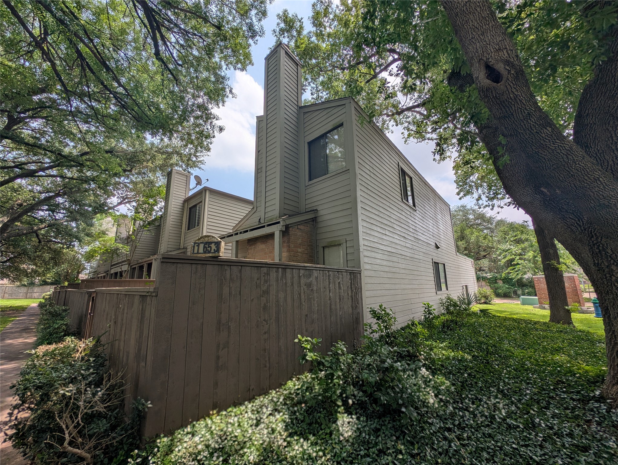 Quaint townhouse in, featuring modern architecture with a two-story design and a garage. The well-maintained exterior is surrounded by greenery.