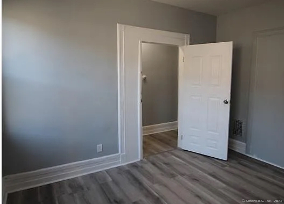301 Dover Street, Unit 2 Bridgeport, CT 06610 - Photo 1 of 2 an empty room with wooden floor and closet
