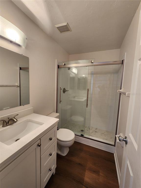 5823 Southwest 9th Place, Unit H55 Gainesville, FL 32607 - Photo 33 of 50 a bathroom with a granite countertop sink toilet a mirror and shower