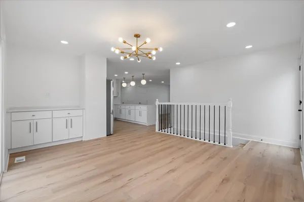 a view of a room with wooden floor and a ceiling fan