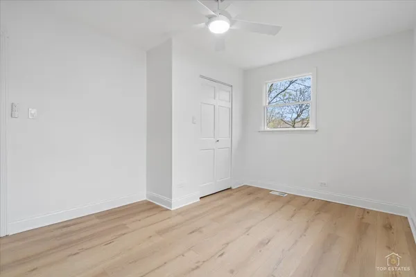 a view of an empty room with wooden floor and a staircase