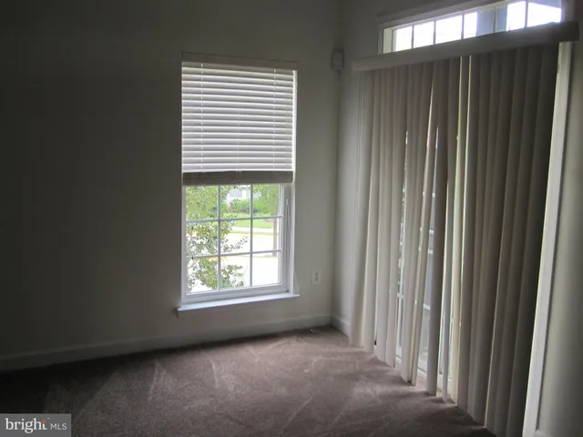 a view of a livingroom with an empty space and a window