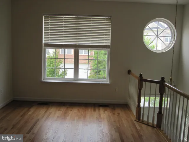 a view of a livingroom with wooden floor and a window