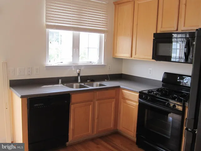 a kitchen with stainless steel appliances a stove a sink and a microwave