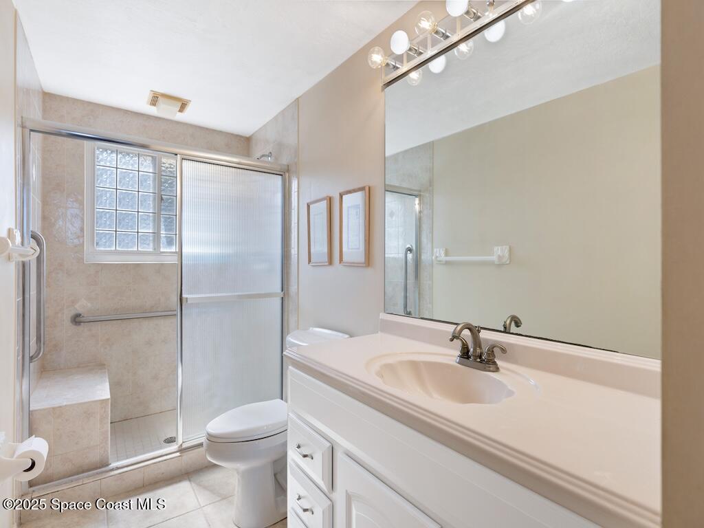 8820 44th Avenue Sebastian, FL 32958 - Photo 18 of 48 a bathroom with a sink toilet a mirror and shower