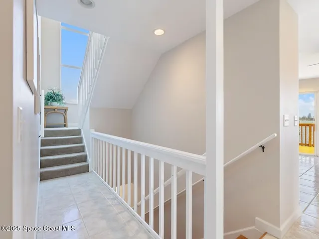 a view of a hallway with wooden floor and a bathroom