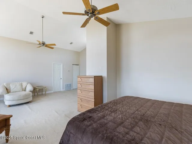 a bedroom with a bed and a ceiling fan