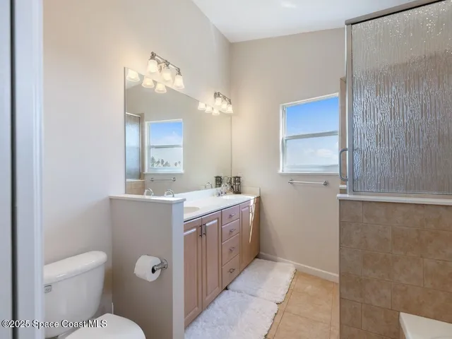 a view of bathroom with a toilet sink and mirror