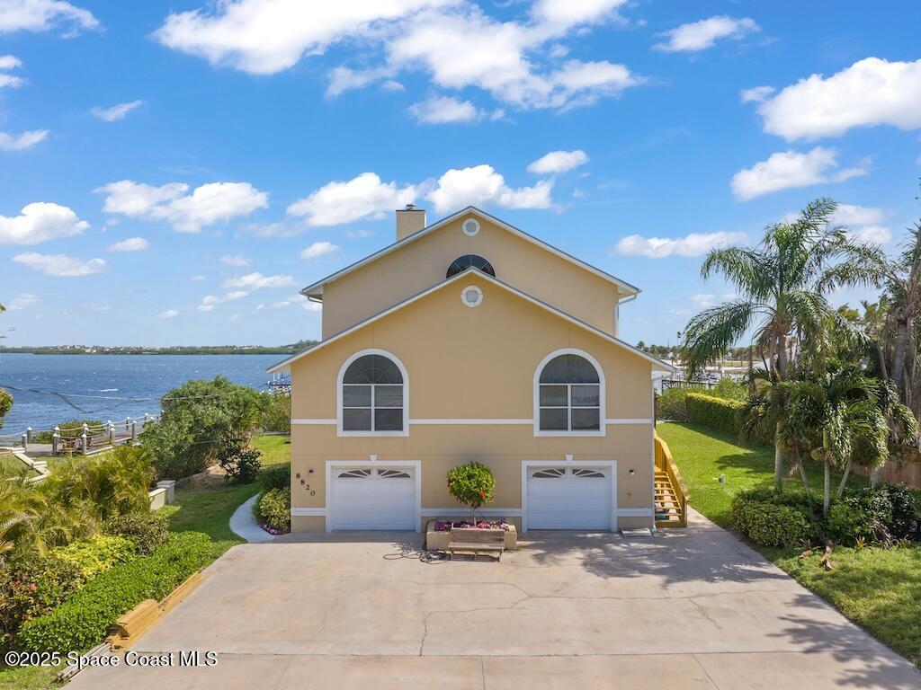 8820 44th Avenue Sebastian, FL 32958 - Photo 6 of 48 a front view of a house with a yard and potted plants