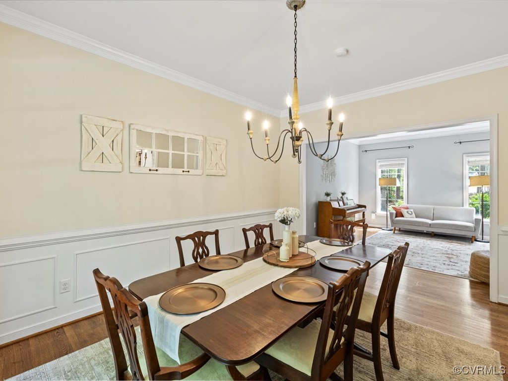 15418 Foxvale Way Midlothian, VA 23112 - Photo 14 of 50 a dining room with wooden floor a chandelier a wooden table and chairs