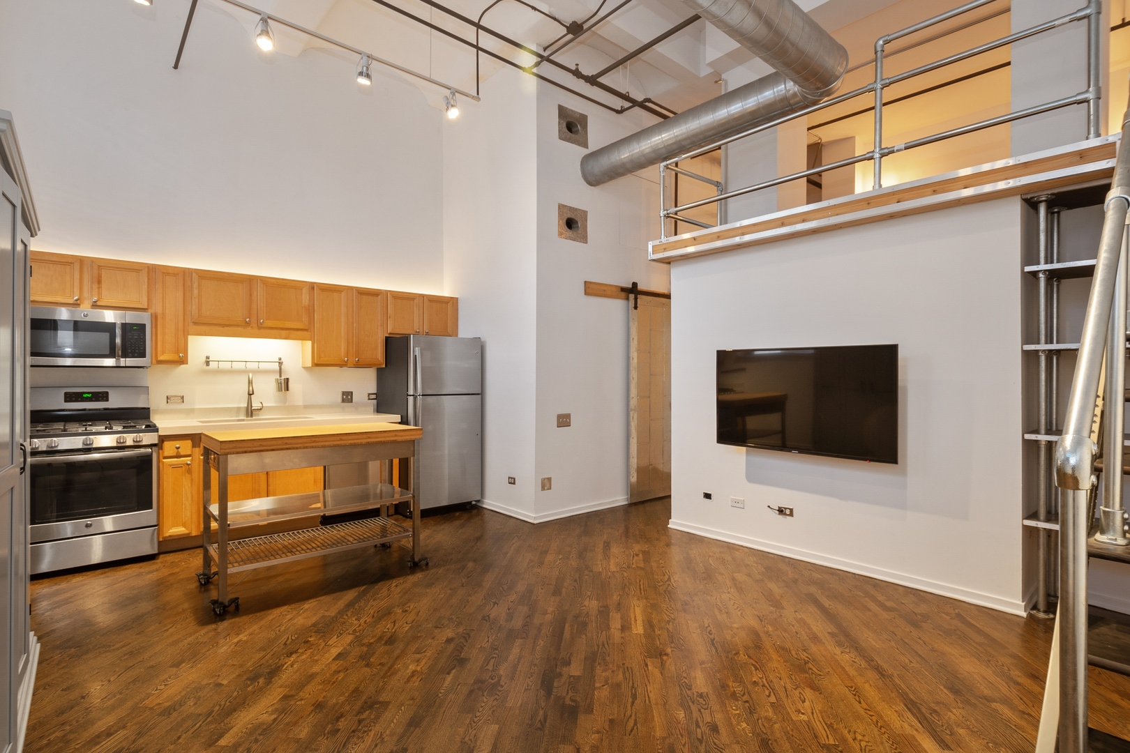 500 South Clinton Street, Unit 101 Chicago, IL 60607 - Photo 2 of 11 a living room with stainless steel appliances furniture and a flat screen tv