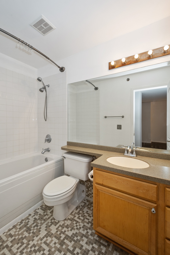 500 South Clinton Street, Unit 101 Chicago, IL 60607 - Photo 8 of 11 a bathroom with a granite countertop toilet a sink and a bathtub