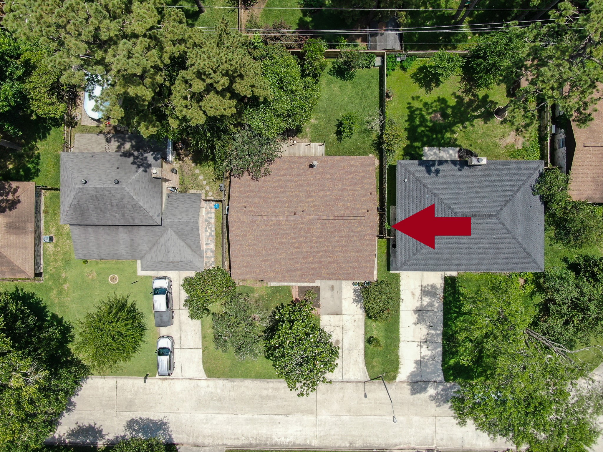 4314 Enchantedgate Drive Spring, TX 77373 - Photo 43 of 47 Aerial view showcases a suburban neighborhood. The property highlighted by a red arrow features a well-maintained yard, driveway, and is surrounded by greenery, providing a private and serene setting.