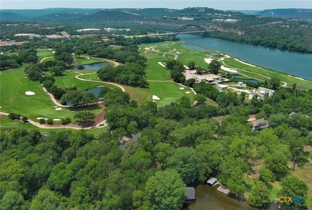 an aerial view of lake with residential houses with outdoor space and trees