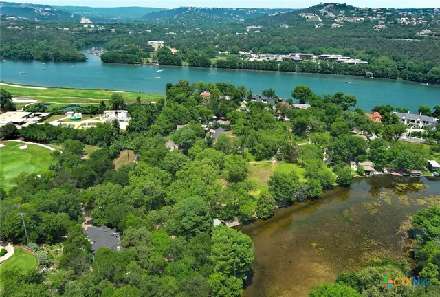 an aerial view of a residential houses with outdoor space and lake view