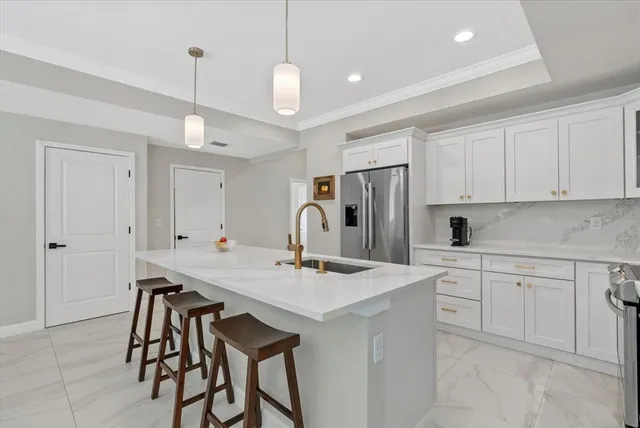a kitchen with stainless steel appliances granite countertop a table chairs sink and cabinets
