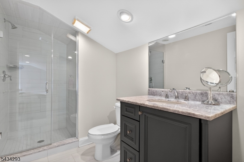 921 Harding Street Westfield, NJ 07090 - Photo 37 of 50 a bathroom with a granite countertop sink a toilet and shower