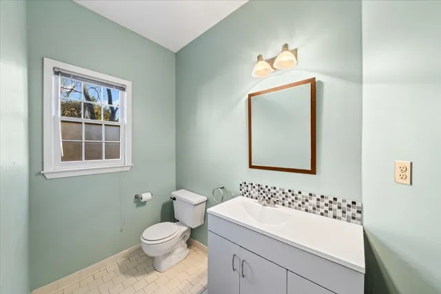 a bathroom with a toilet sink and mirror