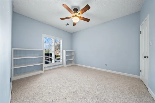 a view of an empty room with a ceiling fan