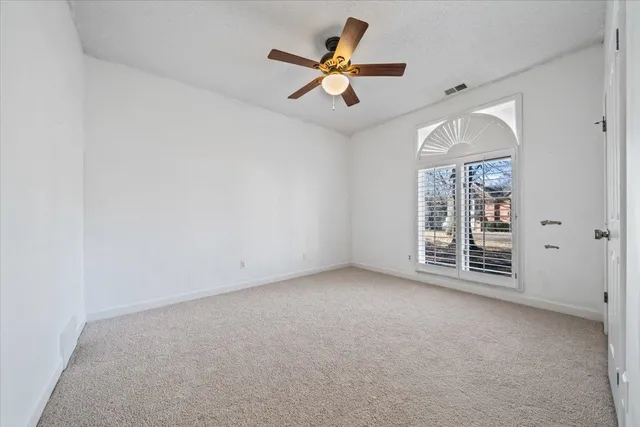 an empty room with fan and windows