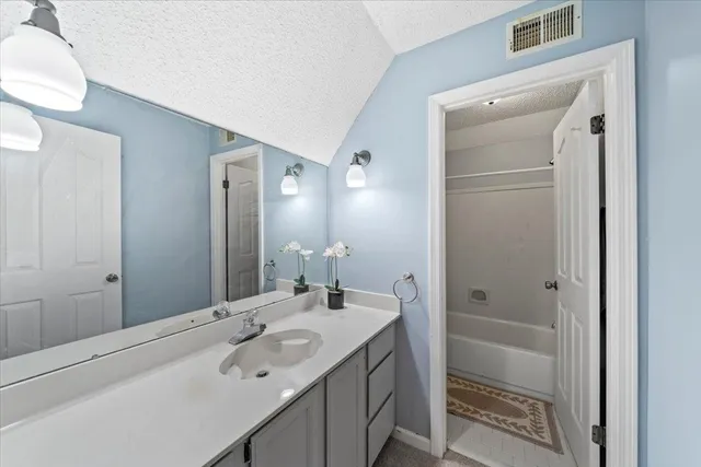 a bathroom with a sink a mirror and a shower