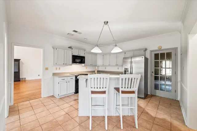 a view of kitchen with stainless steel appliances granite countertop cabinets and chair