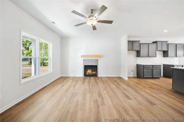 a view of an empty room with a fireplace and a window