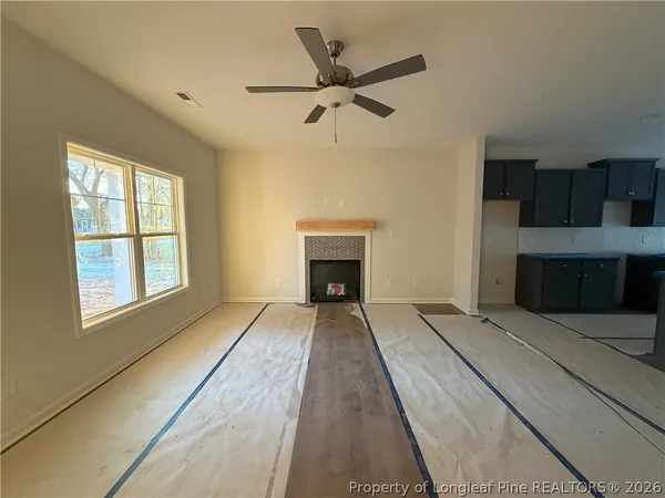 a view of an empty room with a fireplace and a window