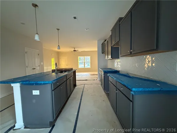 a large kitchen with kitchen island a sink a stove and a wooden floors