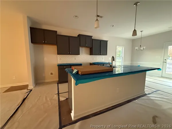 a kitchen with stainless steel appliances kitchen island granite countertop a refrigerator and a stove top oven