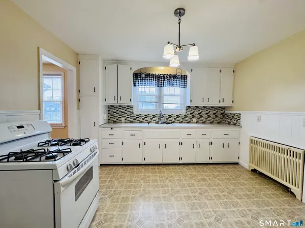 a kitchen with granite countertop a stove a sink and a granite counter tops