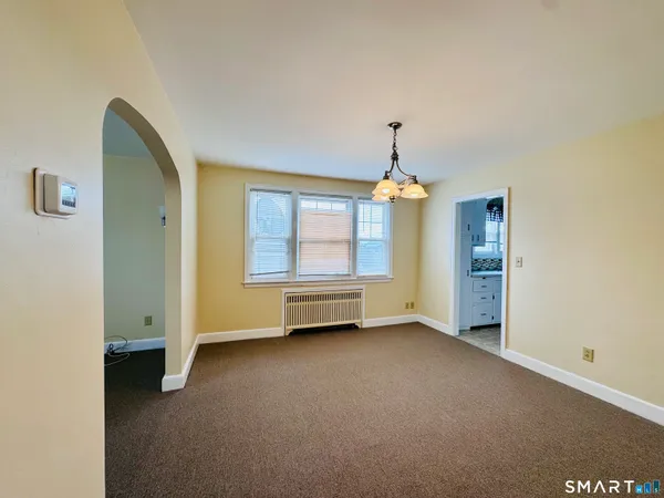 an empty room with windows and cabinet